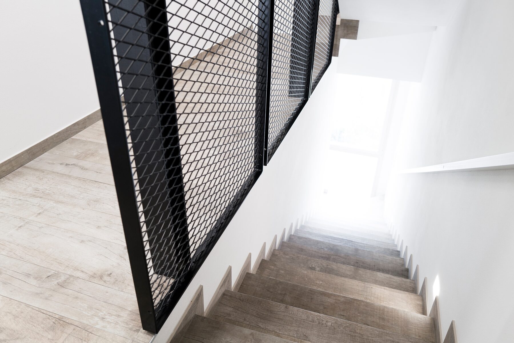 Black mesh staircase railing looking down