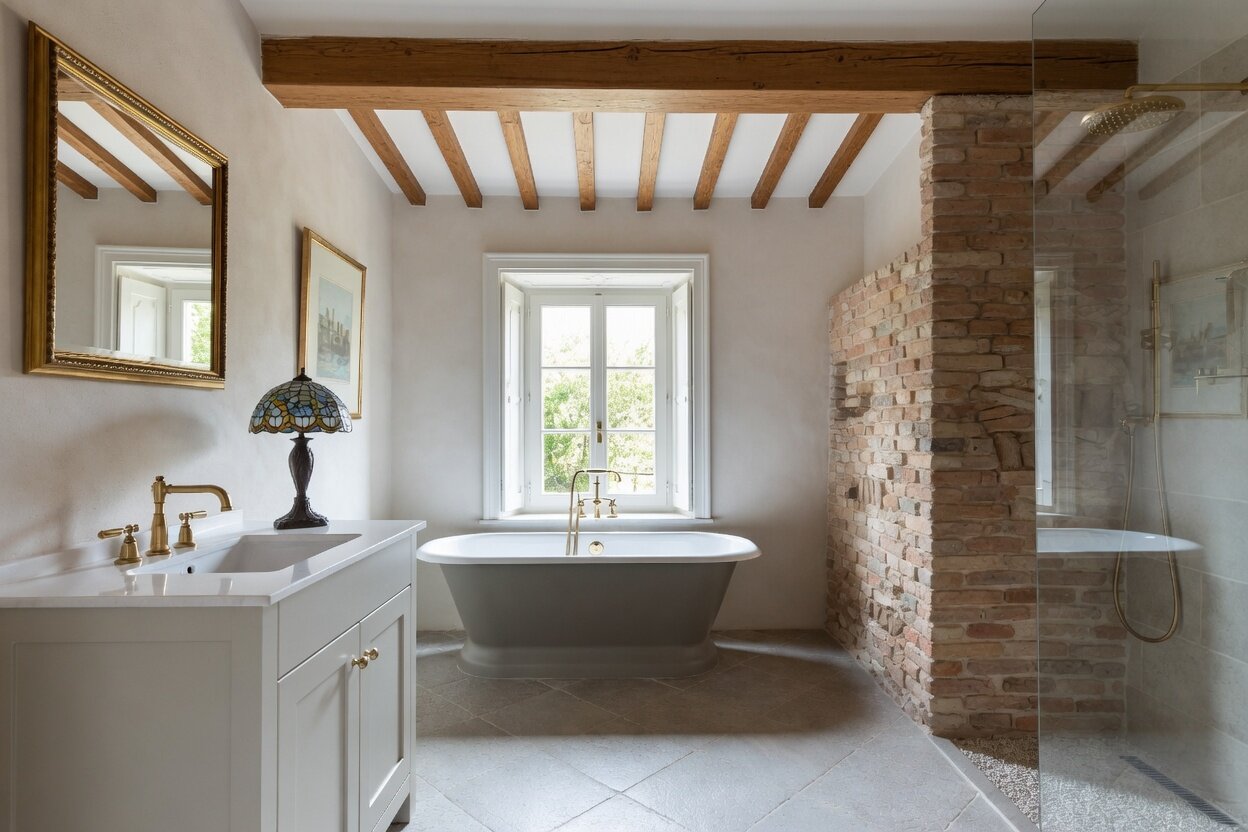 Classic bathroom with freestanding tub and exposed brick